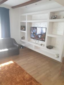 AgrişにあるFancy houseの黒いソファと薄型テレビのあるリビングルーム