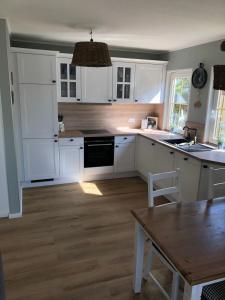 a kitchen with white cabinets and a wooden floor at Landidyll in Silenz