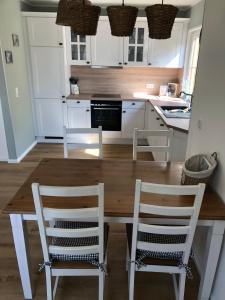 a kitchen with a wooden table and two chairs at Landidyll 
