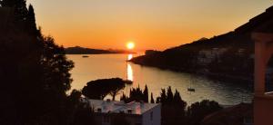 a sunset over a body of water with a city at Apartment Zara in Dubrovnik