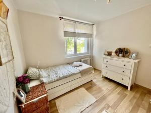 een slaapkamer met een bed, een raam en een dressoir bij Apartament Sea Nest Brzeźno, blisko morza in Gdańsk