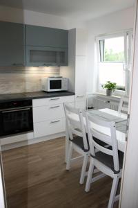 a kitchen with a table and two white chairs at Auf dem Kleeberg in Niederzissen