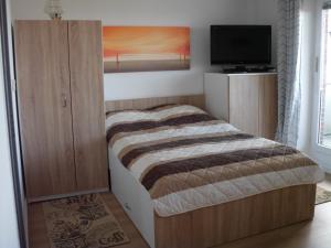 a bedroom with a bed and a tv in it at Tief 10 Wohnung 408 in Wangerland