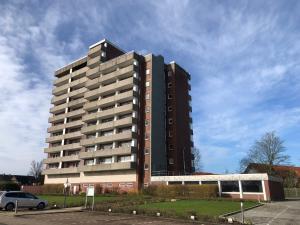 a tall building with a car parked in front of it at Tief 10 Wohnung 408 in Wangerland