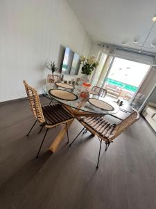 une salle à manger avec une table et des chaises en verre dans l'établissement T2 cosy Ajaccio, à Ajaccio