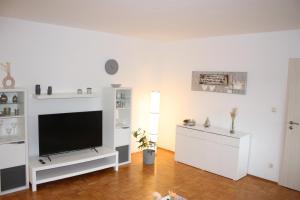 a white living room with a flat screen tv at Auf dem Kleeberg in Niederzissen