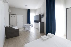 1 dormitorio con 1 cama y cocina con mesa en Residence Conchiglie, en Marina Romea