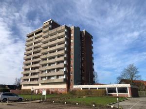 um edifício alto com um carro estacionado em frente em Tief 10 Wohnung 102 Heimathafen em Wangerland