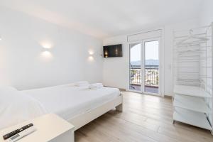 - une chambre blanche avec un lit et une fenêtre dans l'établissement Apartamento WELCS EMP-064- frente al Mar, à Empuriabrava