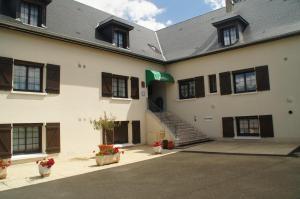 a large white building with stairs and flowers in pots at Contact Hôtel du Relais Thouars in Thouars