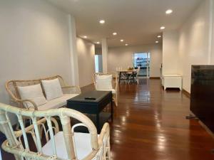 un soggiorno con un divano, sedie e un tavolo di Forgotten Hostel Silom a Bang Rak