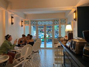 un gruppo di persone sedute ai tavoli di un ristorante di Forgotten Hostel Silom a Bang Rak
