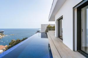a swimming pool on the balcony of a house overlooking the ocean at Villa Welcs EMP 083 con piscina infinita in Roses