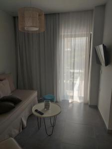 ein Wohnzimmer mit einem Sofa und einem Tisch in der Unterkunft Zante Flower Studios & Apartments in Alikanas