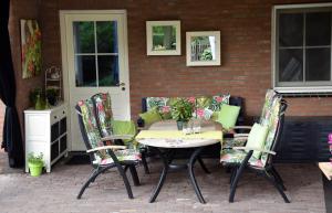 un patio con mesa y sillas en B&B De Rozenhorst en Baarlo