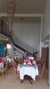 eine Gruppe von Personen, die in einem Restaurant an Tischen sitzen in der Unterkunft Sophia Hotel in Daressalam