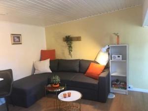 ein Wohnzimmer mit einem Sofa und einem Tisch in der Unterkunft Indbydende bed & breakfast med dejlig gårdhave in Randers
