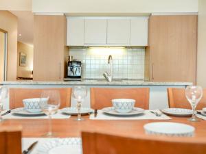 a kitchen with a table with plates and wine glasses at Relax in Style Comfort in Victor Harbor