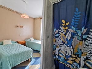 Hotel le Pasteur في رويان: غرفة نوم بسرير وستارة في غرفة