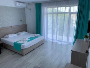 a bedroom with a bed and a large window at Vila Elva in Eforie Sud