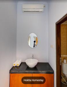 ein Bad mit einem Waschbecken und einem Spiegel in der Unterkunft Hokita Home Stay in Nusa Lembongan