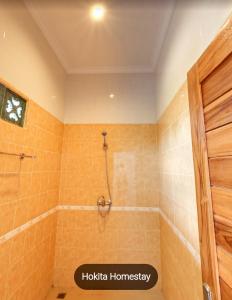 ein Bad mit einer Dusche und orangefarbenen Fliesen in der Unterkunft Hokita Home Stay in Nusa Lembongan