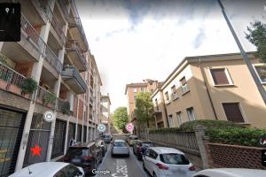 una calle de la ciudad con coches aparcados en la calle en F L O R E N T I N Design Apartment ChicLife en Bergamo