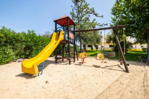 un parque infantil con un tobogán en la arena en Villa Arrifes, en Albufeira