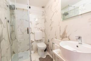 um banheiro com vaso sanitário, pia e chuveiro em Appartamento confortevole em Génova mais 14 fotografias