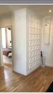 een woonkamer met een witte muur en een hal bij bel appartement proche centre parking gratuit in Straatsburg