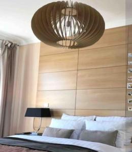 een slaapkamer met een grote kroonluchter boven een bed bij bel appartement proche centre parking gratuit in Straatsburg
