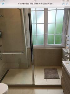 een badkamer met een douche, een toilet en een raam bij bel appartement proche centre parking gratuit in Straatsburg