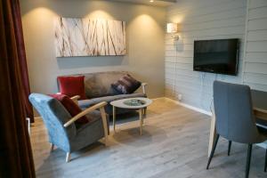 un soggiorno con divano e TV di Florø Rorbu a Florø