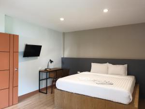 a bedroom with a bed and a tv on a wall at My Friend's House Villa in Ban Karon +13 photos