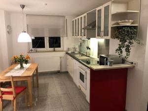 a kitchen with white cabinets and a wooden table at Wohnung 1 Altstadt in Ulm