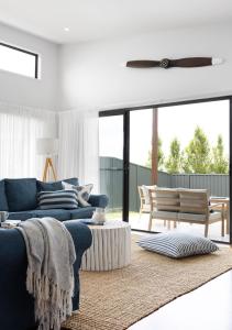 a living room with a blue couch and a table at Seagrass in Vincentia