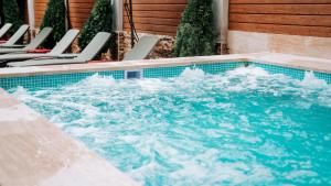 a pool of water with chairs and chairs at Hotel Sapphire Bakuriani in Bakuriani