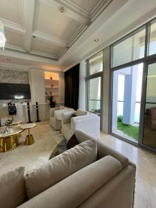 a living room with white furniture and a large window at أجنحة فرزاتشي برج داماك الجوهرة in Jeddah