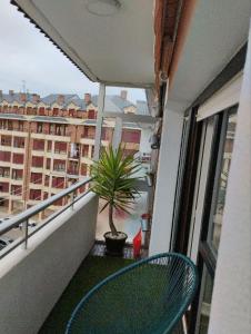 a balcony with a chair and a potted plant at La Casa de Kiko. in Santoña