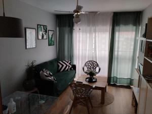 a living room with a green couch and a table at La Casa de Kiko. in Santoña