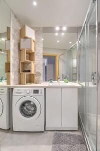 ein Badezimmer mit Waschmaschine und Waschbecken in der Unterkunft Family Center Spot in Posen