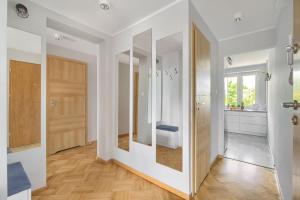 ein Zimmer mit einem Flur mit weißen Wänden und Holzböden in der Unterkunft Family Center Spot in Posen + 34 Fotos