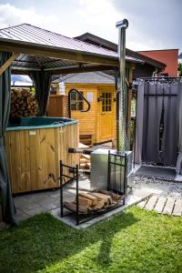 einen Hinterhof mit einem Whirlpool und einem Grill in der Unterkunft Gästehaus Waldrand Garni in Wiesing