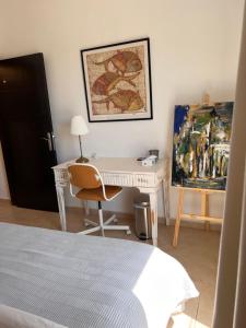 a bedroom with a desk and a painting on the wall at The Arabian Oryx in Amman
