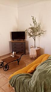 a bedroom with a bed and a table with a tv at Le mas du bosc in Mauguio