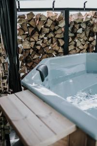 a bath tub sitting next to a pile of fire wood at Gästehaus Waldrand Garni in Wiesing