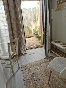 um quarto com uma cadeira e uma porta aberta em Au Poème du Chêne, Logement indépendant, Intimité, SPA et bien-être em Basse-Goulaine