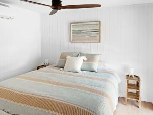 a bedroom with a bed and a ceiling fan at Pod on the Park in Kiama