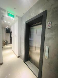 einen Aufzug in einem Gebäude mit einem Schild an der Wand in der Unterkunft oxy suites 2-06 at Shop House Meisterstadt Pollux Habibie in Batam Center