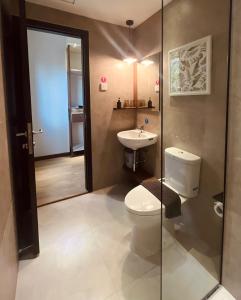 a bathroom with a toilet and a sink at oxy suites 2-06 at Shop House Meisterstadt Pollux Habibie in Batam Center